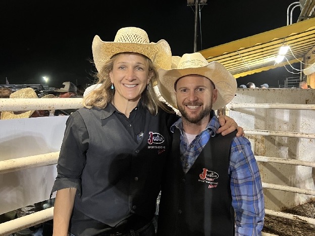Dr. FitzPatrick in a sports medicine team vest at a rodeo, beside the chutes